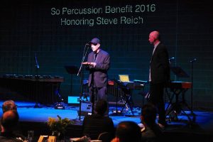 Steve Reich accepting the pulse ‘piece of wood’ from Jason Treuting at Sō Percussion Benefit Concert, May 17, 2016. Photo: Marc Akiyama. 